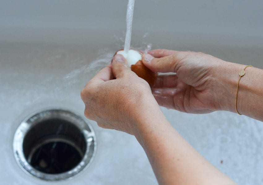 peeling eggs under running tap water