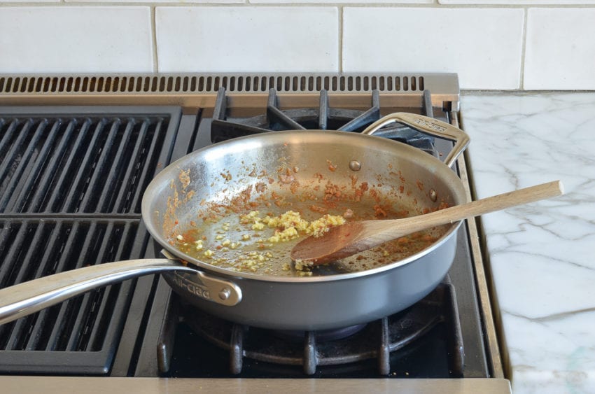 garlic and sausage drippings in skillet