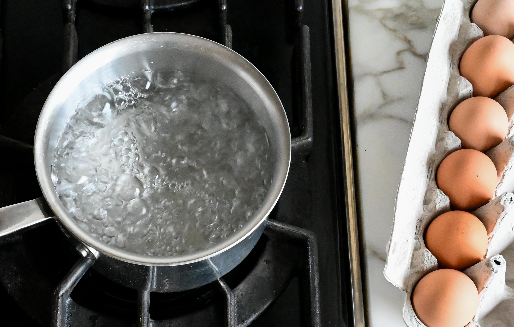 Bringing water to a boil for soft-boiled eggs on a stove. 