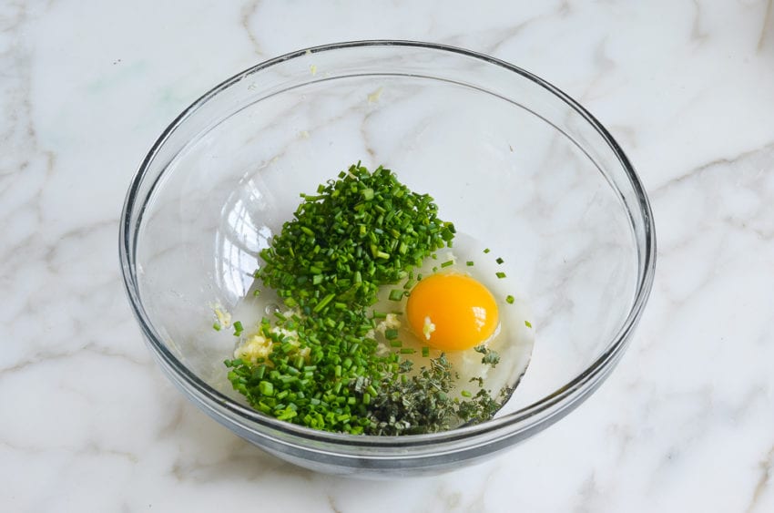 Egg and herbs in a bowl.