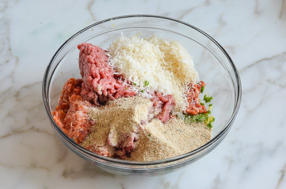 Bowl of unmixed meatball mixture.
