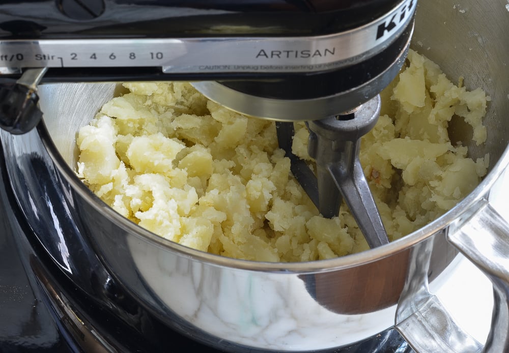 Cooked potatoes in a stand mixer.