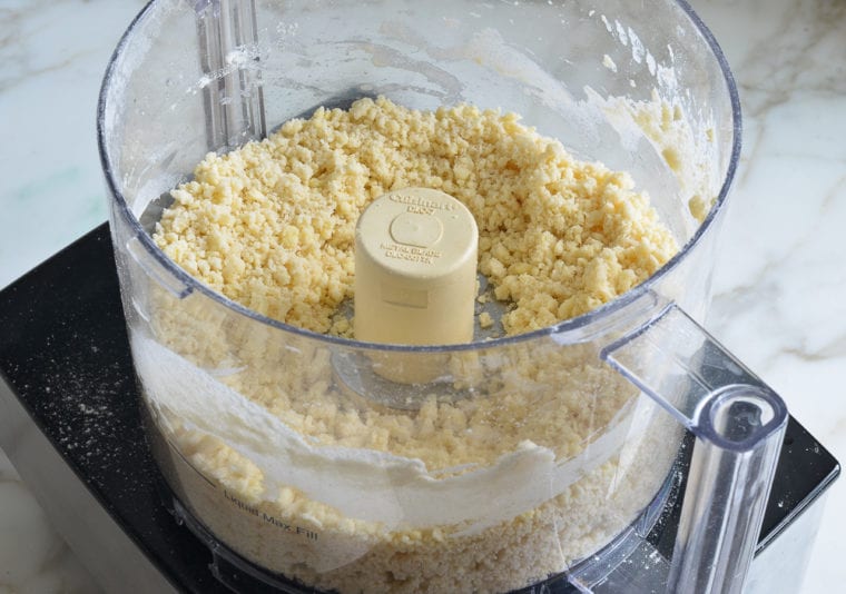 Pie crust ingredients crumbled in a food processor.