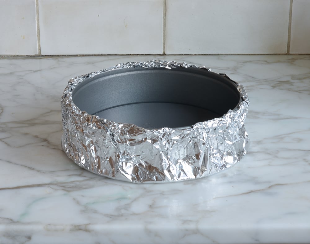 Springform pan wrapped in aluminum foil.