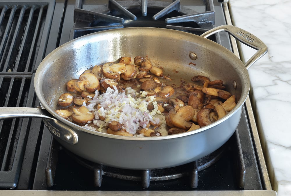 Cooked mushrooms with other ingredients in a skillet.