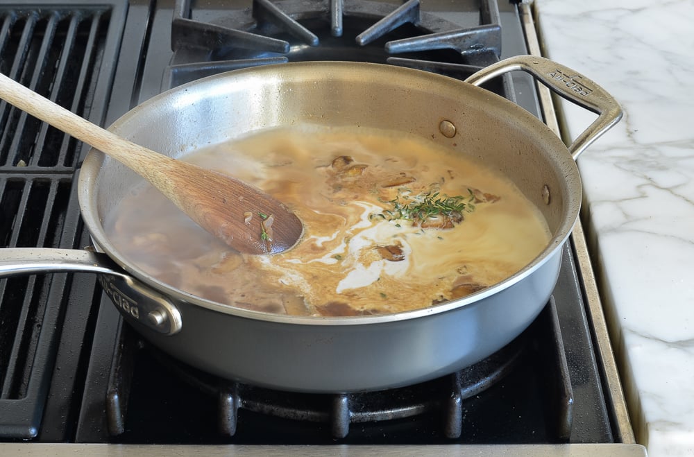 Cream with mushrooms in a skillet.