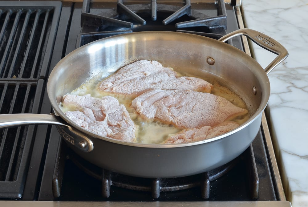 Seasoned chicken in a skillet.