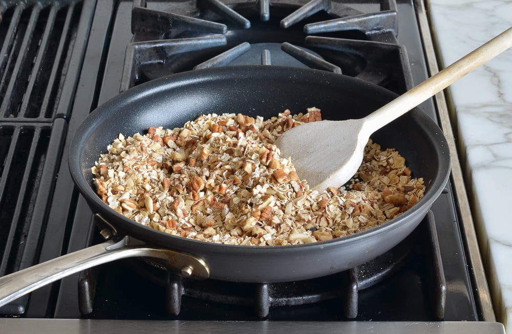 Oats and nuts in a skillet.