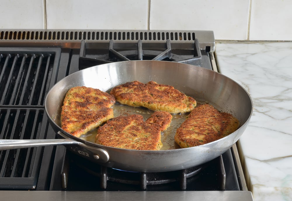 pan-frying the chicken piccata (golden color).