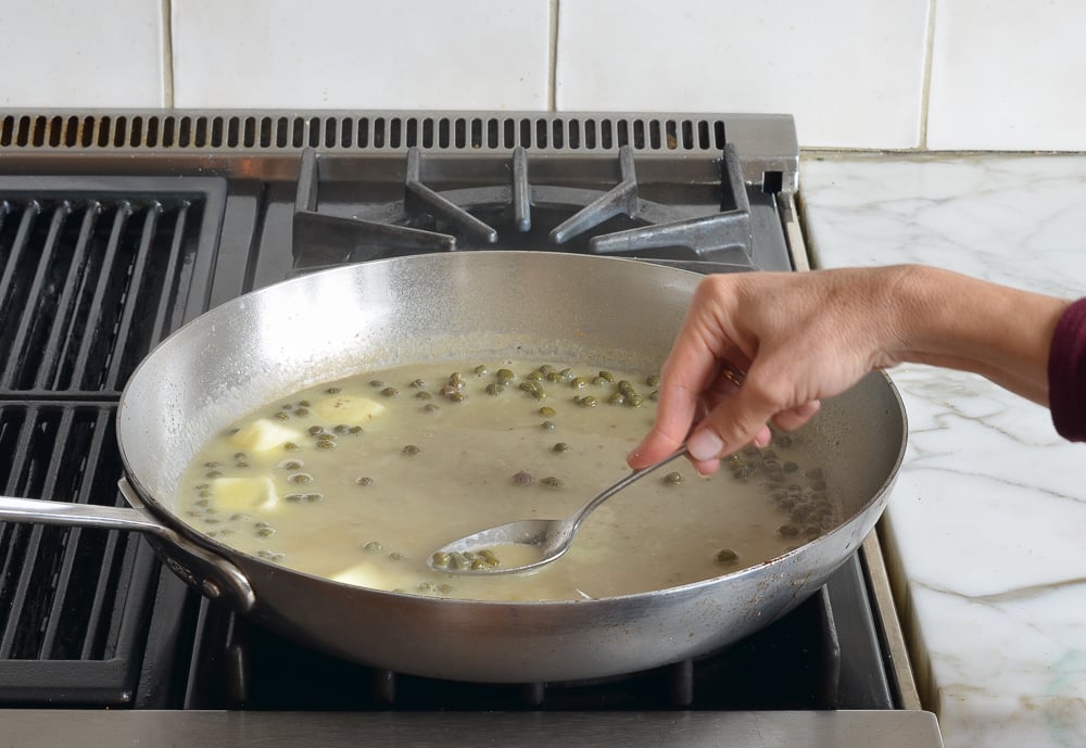 swirling butter into the chicken piccata sauce.