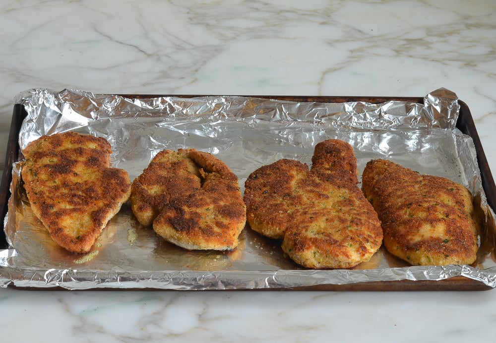 chicken piccata arranged on baking sheet.