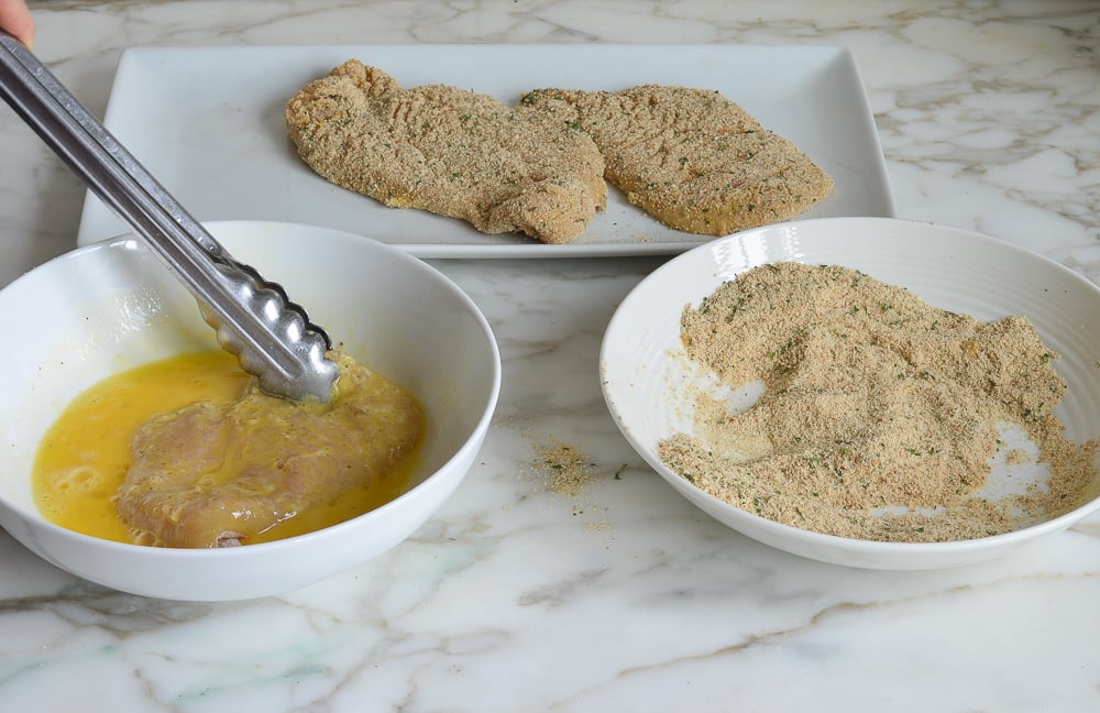 dipping the chicken in eggs.