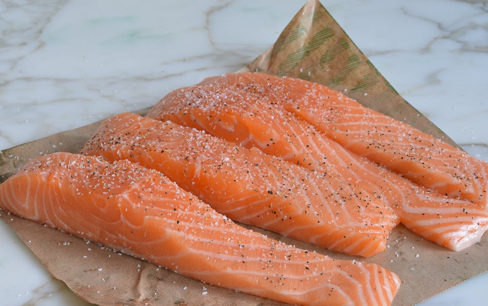 Seasoned salmon on parchment paper.