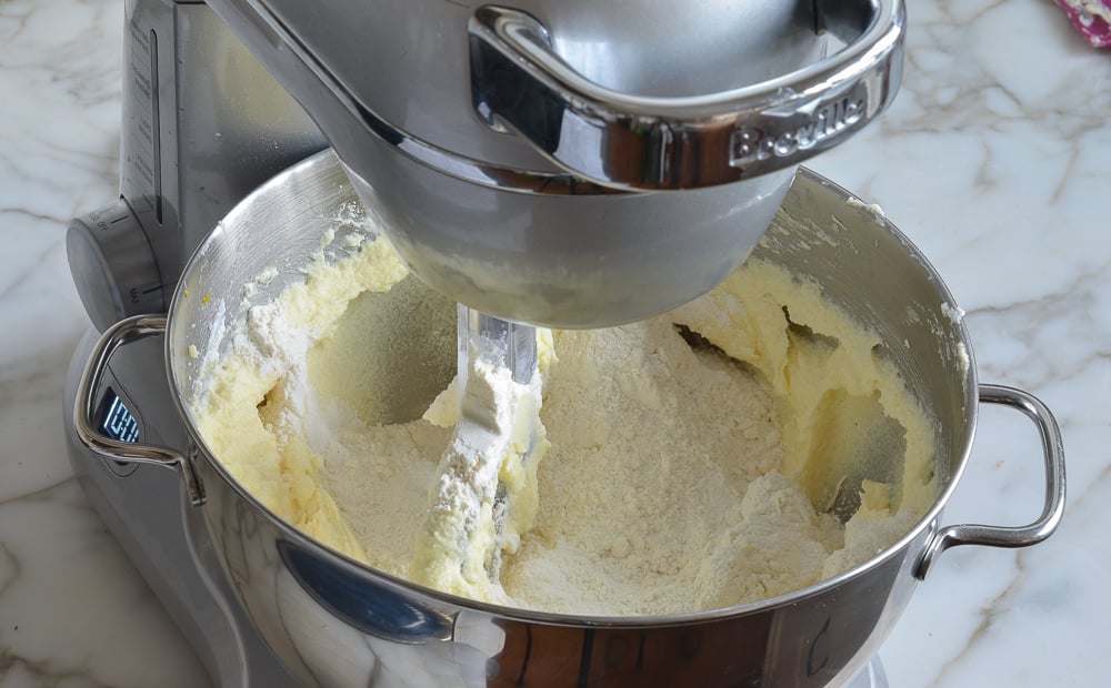 Flour in a stand mixer with a butter mixture.