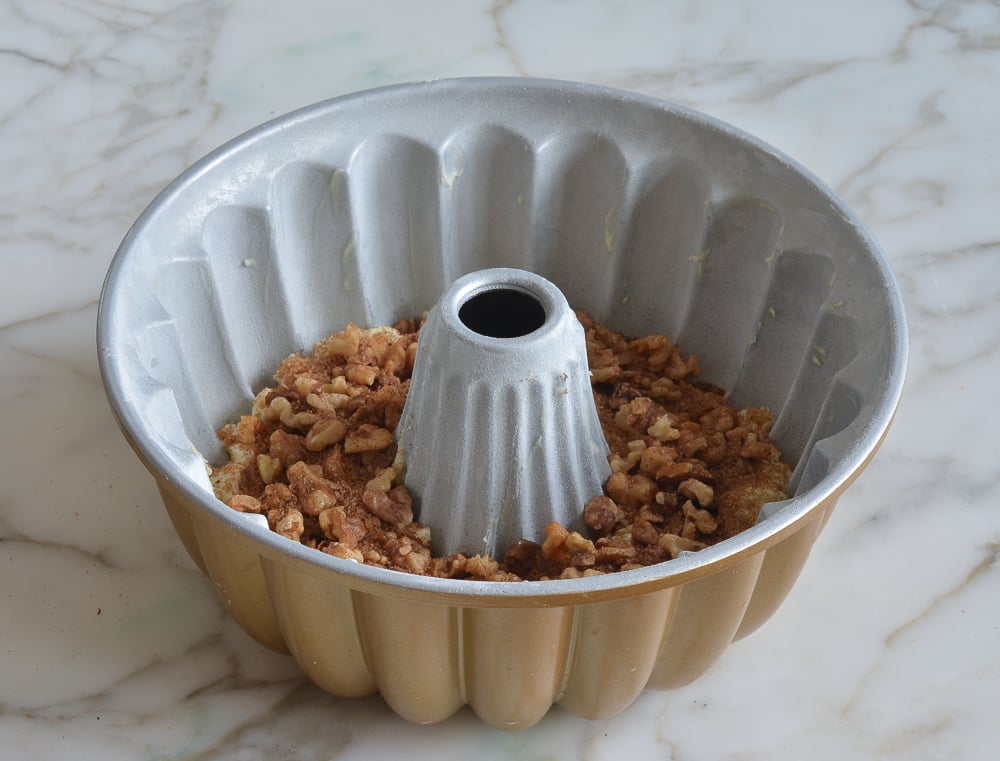 Walnut mix in a Bundt cake pan with sour cream coffee cake batter.