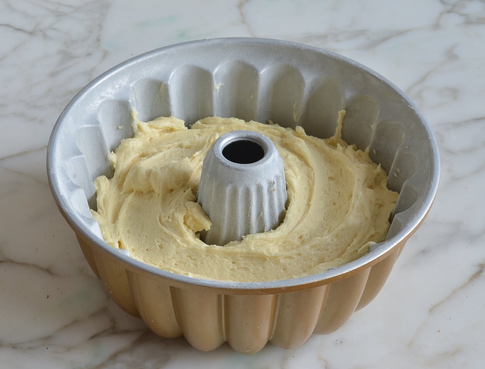 Layer of sour cream coffee cake batter in a Bundt pan.