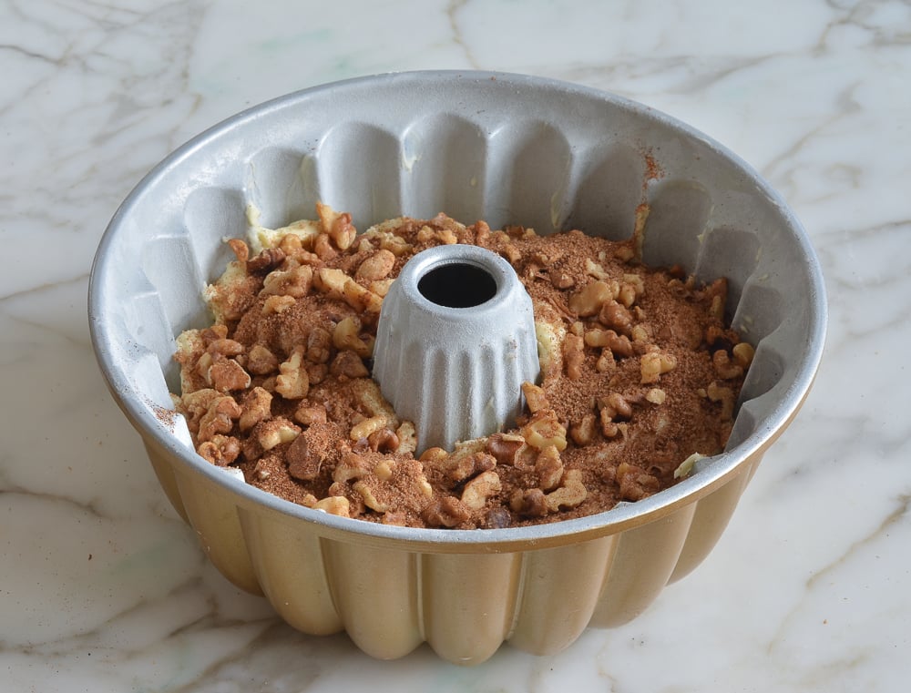 Layer of walnut and cinnamon mixture in a Bundt pan.