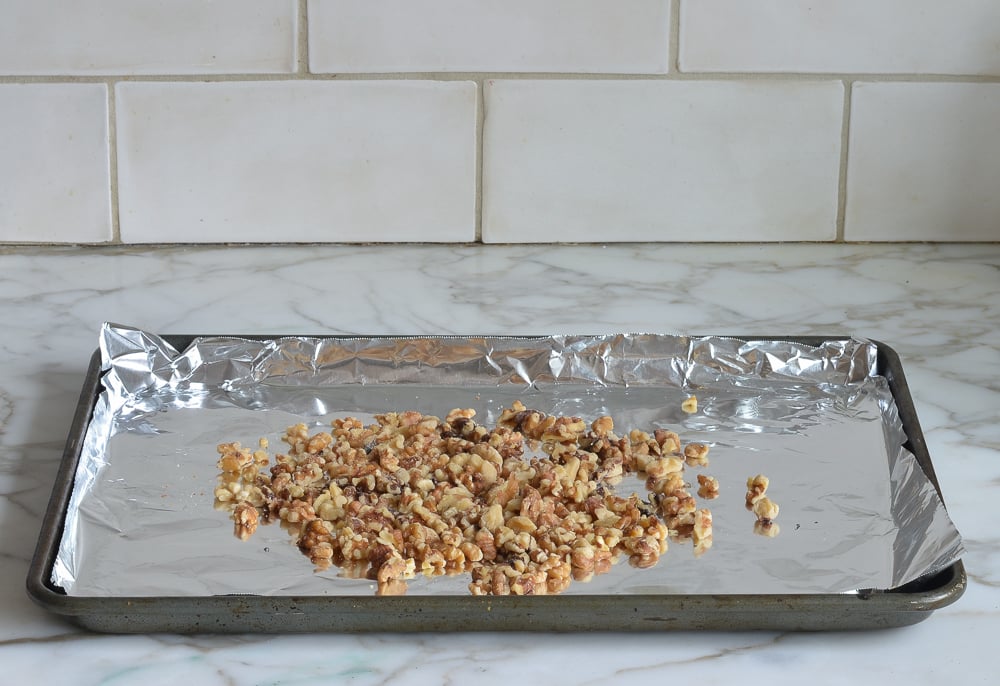 Walnuts on a lined baking sheet.