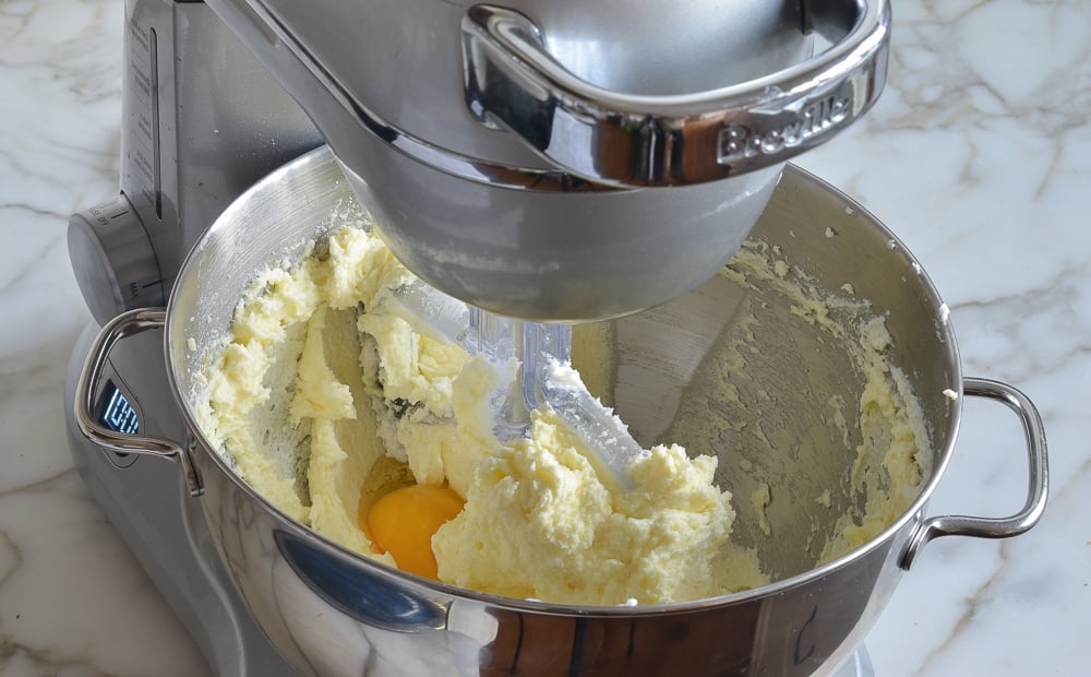 Egg in a stand mixer with beaten sugar and butter.
