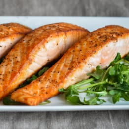 Salmon on a plate with greens.