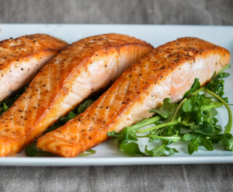 Salmon on a plate with greens.