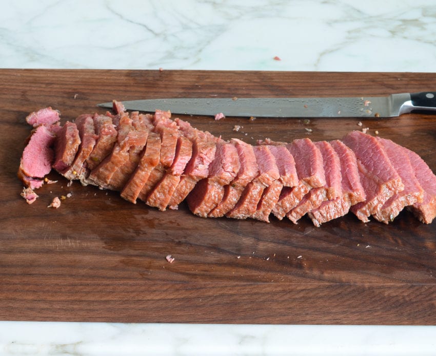 making corned beef and cabbage - slicing corned beef on cutting board