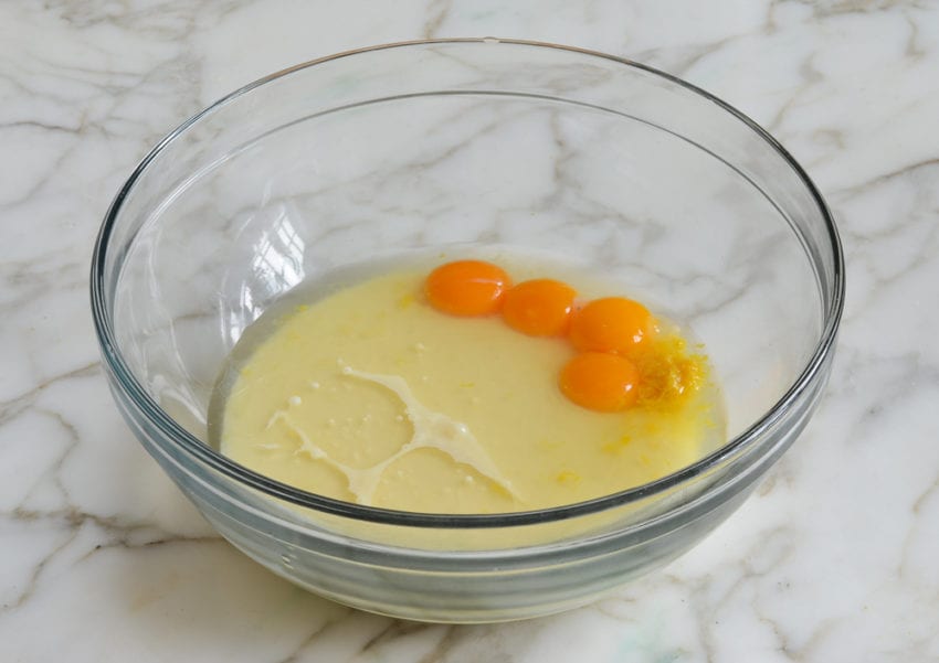 Egg yolks, sweetened condensed milk, and lemon in a bowl.