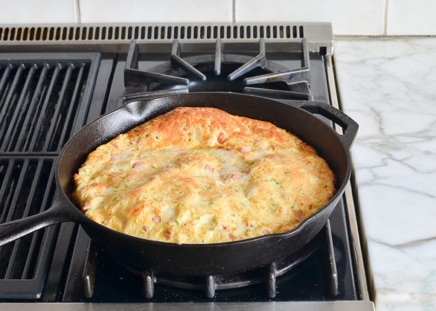 Ham and cheese oven-puffed pancake in a skillet.
