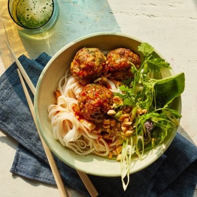 Vietnamese-style meatballs with chili sauce in a bowl over noodles.