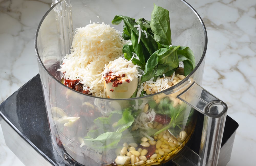 Pesto ingredients in a food processor.
