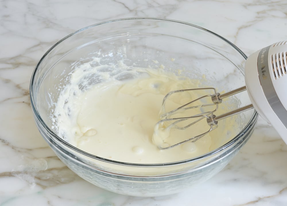 Heavy cream in a bowl with a cream cheese mixture.