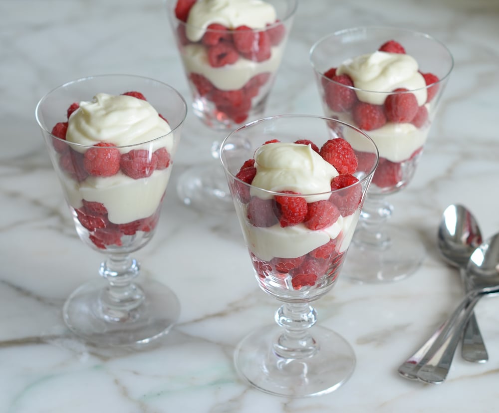 Stemmed glasses filled with Raspberry and Cream Parfaits.