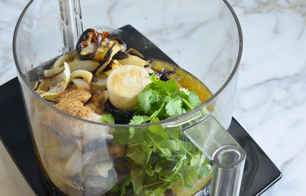 Roasted vegetables and seasonings in a food processor.