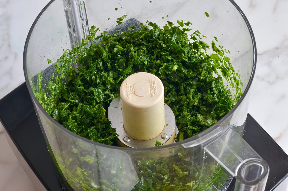 Chopped kale and basil in a food processor.