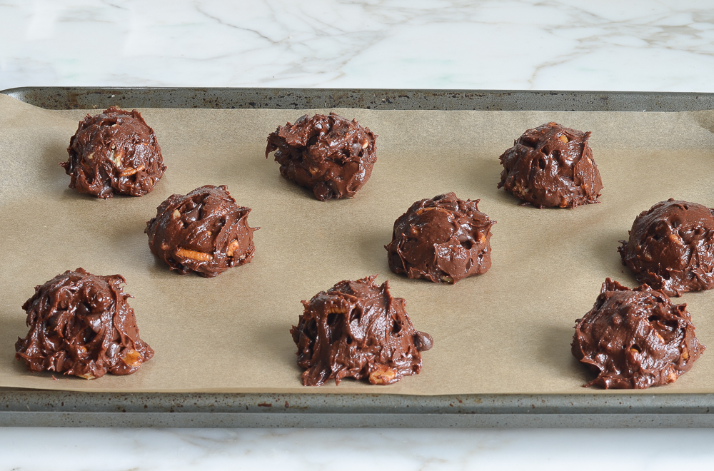 Scoops of blobb dough on a lined baking sheet.