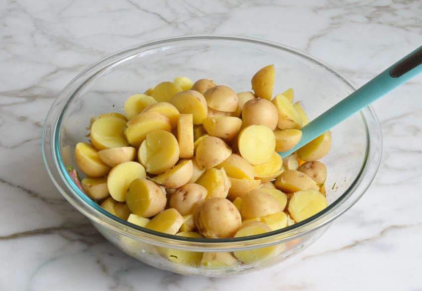 adding potatoes to the vinaigrette