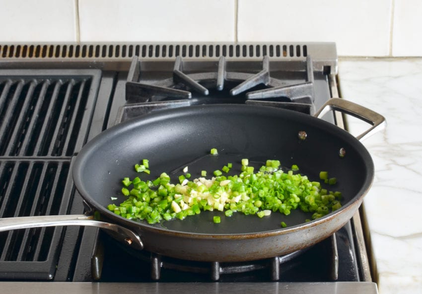 Light scallions, garlic, and jalapeno in a skillet.