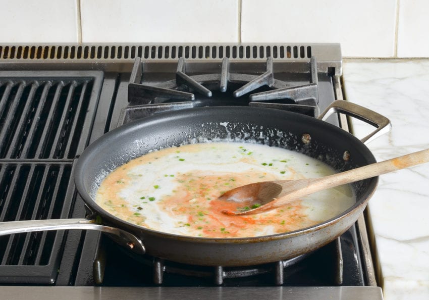 Skillet of simmering coconut milk mixture.