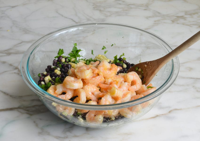 Shrimp in a bowl with black beans and corn.