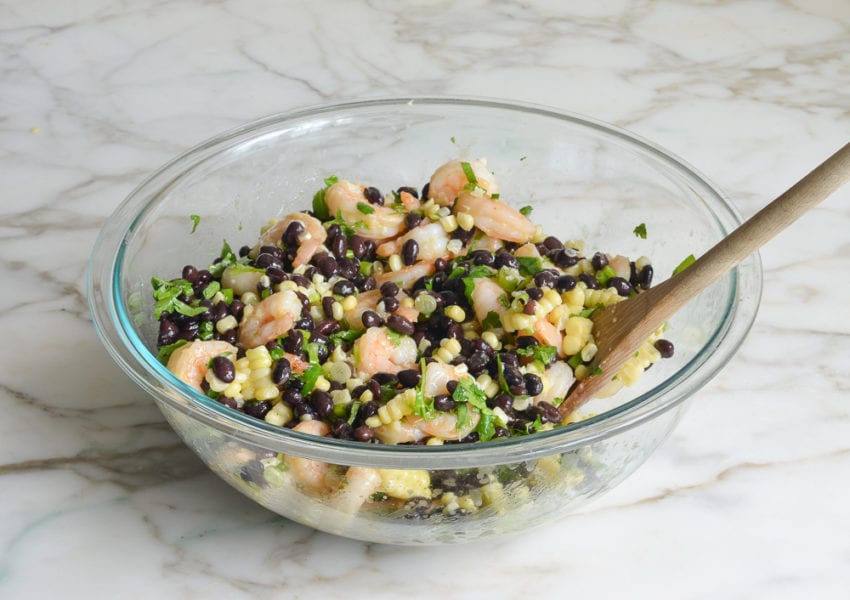 Black bean and shrimp salad in a glass mixing bowl.
