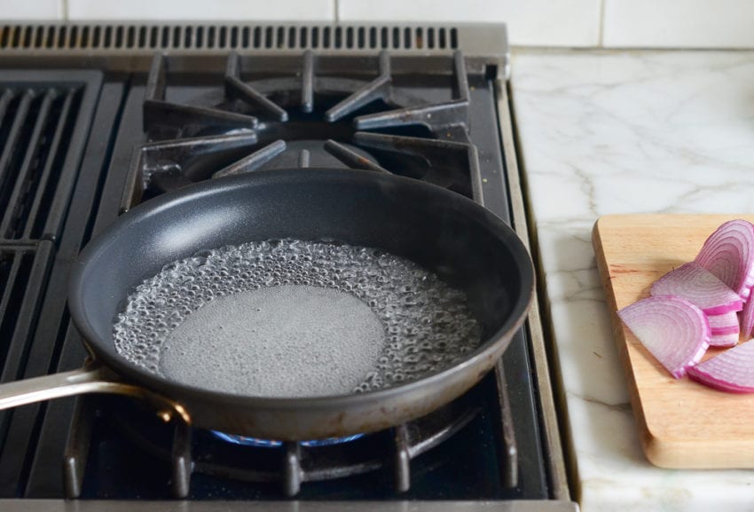 Sugar dissolving into liquid in a pan on the stovetop.