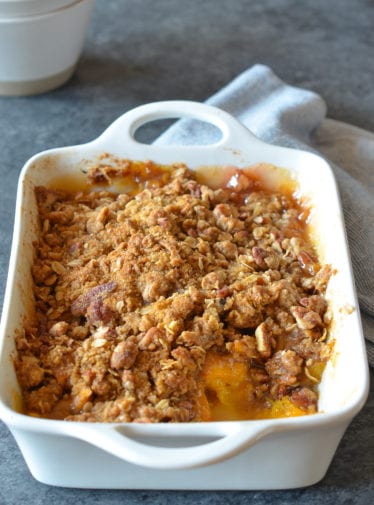 Partially-served Peach Crisp in a baking dish.