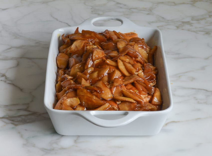 Apple mixture over challah in a baking dish.