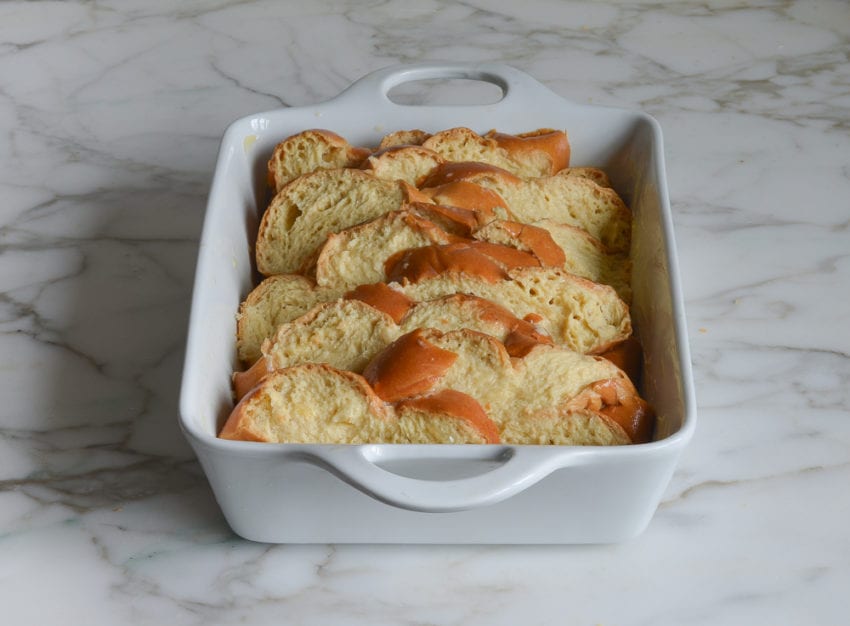 Baking dish full of challah that has been dipped in custard.