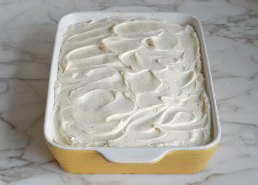 Frosted pumpkin cake in a baking pan.