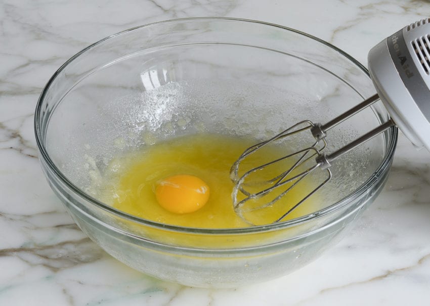 Egg in a bowl with a butter and sugar mixture.