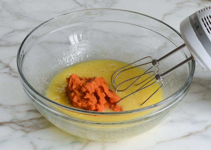 Pile of pumpkin in a bowl with a butter mixture.