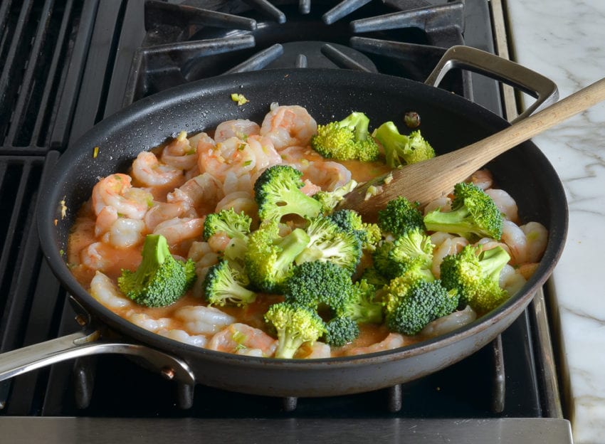 Broccoli in a skillet with shrimp.