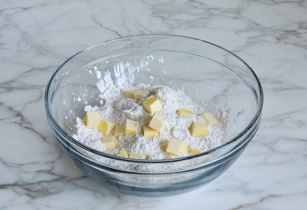 Butter on dry ingredients in a bowl.