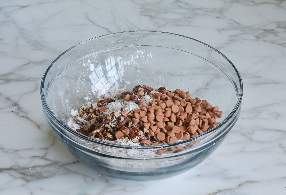 Butterscotch chips and pecans in a bowl with dry ingredients.